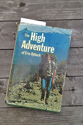 The cover of the High Adventure on Eric Ryback, hiking with mountains in the background