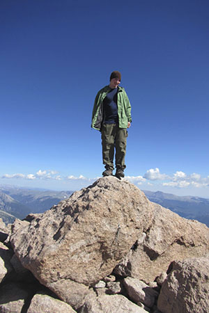 Climber on the boulder like summit of Longs Peak.