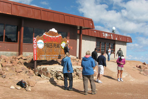 tourists at Pkikes summit sign