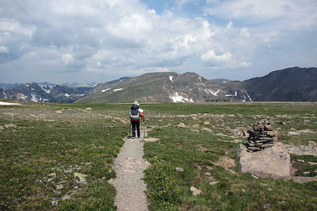 Hiker crossing high route flats heading toward Snowdrift Mountain